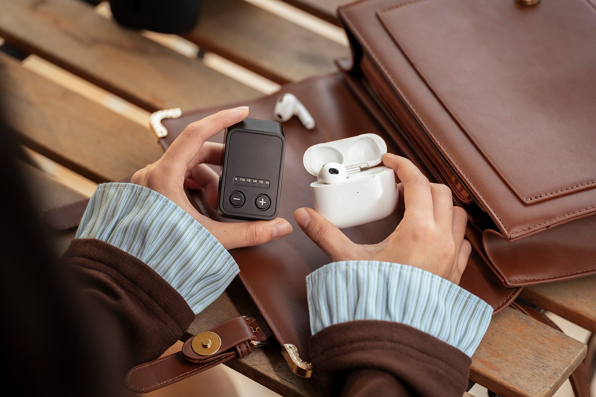 Viltrox Vintage Z2 compact flash held beside wireless earbuds and a small bag